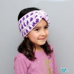 crochet ear warmer in purple and white stitches on a girl