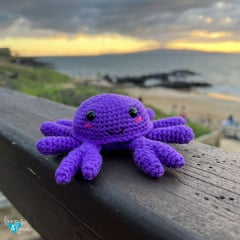 crochet crab amigurumi in purple with ocean background