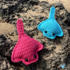 two stingray amigurumi in pink and blue