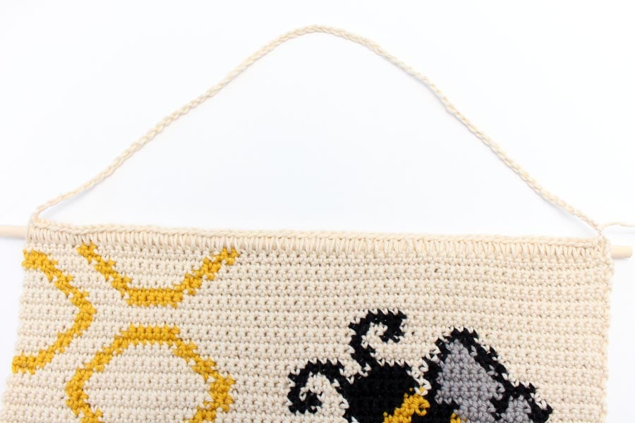 crochet panel featuring honeycomb, a bee, and the bee happy title